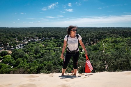 Téléchargez les photos : Femme touristique en grand effort escalade les Dunes du Pilat au Pays Basque, France - en image libre de droit