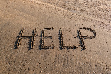Téléchargez les photos : Mot d'aide ou d'aide dessiné dans le sable - en image libre de droit