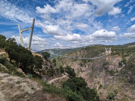 Photo for Panoramic view of the metallic suspension bridge over the Paiva river on a cloudy day in Arouca, Portugal - Royalty Free Image