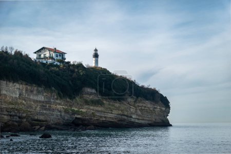 Téléchargez les photos : Altitude falaise ou rocheuse avec un phare et une maison en hauteur à côté de la Petite chambre d'amour à Biarritz au Pays Basque, France - en image libre de droit