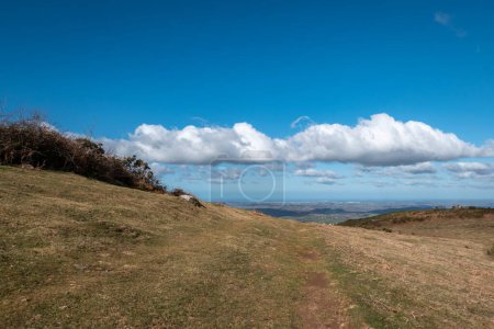 Foto de Explorando la montaña: Un camino de tierra bajo un cielo azul y algunas nubes - Imagen libre de derechos