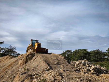 Photo for Backhoe loader in action: Excavating land to build a new road - Royalty Free Image