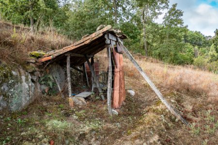 Rustikale Hütte verloren in der ruhigen Landschaft einer ländlichen Landschaft. Kleine verlassene Hütte inmitten eines ländlichen Feldes in der Natur