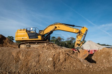 Rotary backhoe loader in action: Transforming land to build a new road