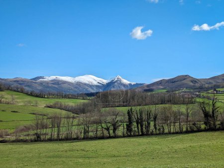 Una encantadora mezcla de campo con verdes pastos y cumbres nevadas en Larrau, en el País Vasco, Francia