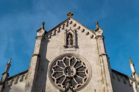 Torre o fachada frontal de la Iglesia de Notre-Dame des Forges en Tarnos, en el País Vasco francés, con una roseta o una ventana de cristal redonda o poligonal con algunos elementos decorativos
