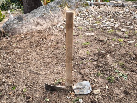 Pickaxe con mango de madera después de cavar y nivelar el suelo