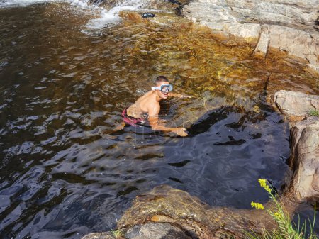 Junger Mann genießt das Wasser eines natürlichen Baches in Fisgas de Ermelo, Portugal
