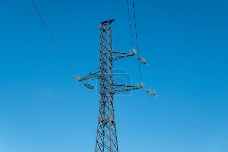 Strommast und Hochspannungsleitungen mit blauem Himmel
