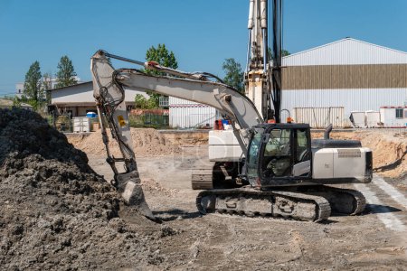 Backhoe loader on a construction site when moving earth in preparation of foundations for the construction of a residential building