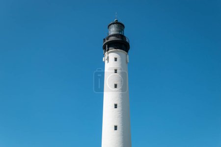 Majestic silhouette: A lighthouse tower rising under a blue sky