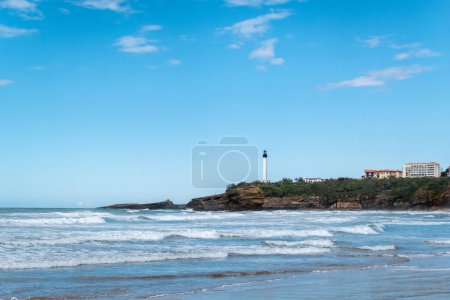 The beach with small waves, the distant lighthouse on top of a large rock formation: The coastal beauty of Biarritz