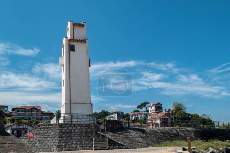 Seaside lighthouse for guidance of maritime navigation with part of the tourist town of Saint Jean de Luz in the French Basque Country