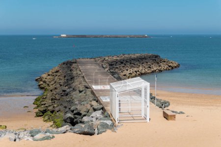 Rock wall on the beach of Saint Jean de Luz, with the Socoa fort in Ciboure in the background in the Basque Country, France