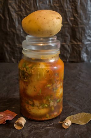 Photo for Raw potatoes mixed with various kitchen seasonings for pickles, macerated for preservation - Royalty Free Image