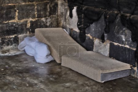 parte de un sofá donde un mendigo duerme en una iglesia en un pequeño rincón para resguardarse del clima