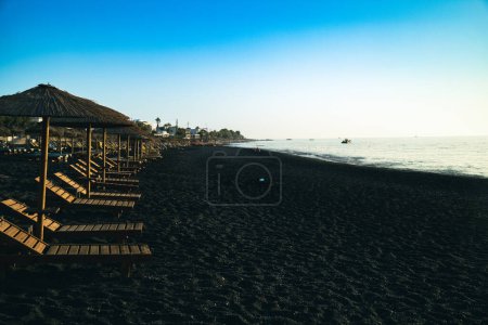 Foto de Paisaje marino y salones Chaise playa negra de Kamari en Santorini. Foto de alta calidad - Imagen libre de derechos