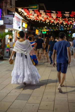 Téléchargez les photos : PLAYA DEL CARMEN, Mexique - Fév 2023 : Une femme habille gracieusement une robe traditionnelle mexicaine, exsudant élégance et fierté culturelle. - en image libre de droit