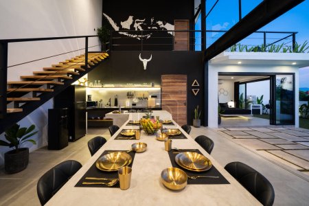 modern kitchen with appliances. Subtle lighting. dining table made of polished concrete.
