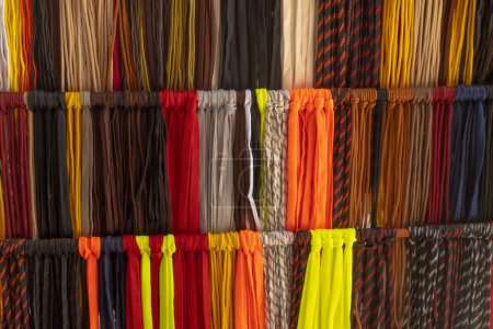 Foto de Fondo de un gran número de cordones de tela multicolor. Un primer plano de las cuerdas colgando en el mostrador del mercado. - Imagen libre de derechos