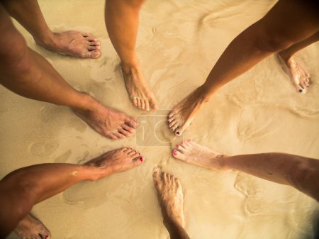 Téléchargez les photos : Groupe de personnes comparant les pieds à la plage - en image libre de droit