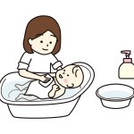 Mother bathing her baby in a baby bath.