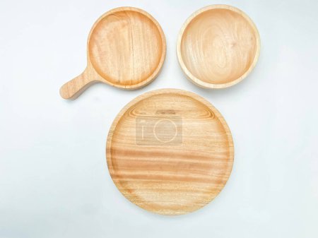 Foto de Colocación plana de la placa de madera vacía, cuenco de madera y placa de madera con un mango sobre fondo blanco. - Imagen libre de derechos