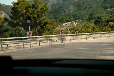 Photo for Travelling by car, road signs, long right turn on curved road - Royalty Free Image