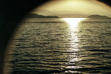 Foto de Vista del atardecer del paisaje marino desde el barco, yate, barco, escotilla redonda de la ventana del barco - Imagen libre de derechos