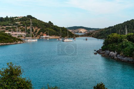 Segelboote vor Anker in der Lakka-Bucht der griechischen Insel Paxos, kleine Taverne an der Küste, Sommerurlaub