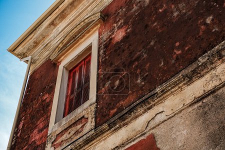 arquitectura griega tradicional, ventana de madera, viejas paredes pintadas, textura rústica, propiedad abandonada necesita mantenimiento