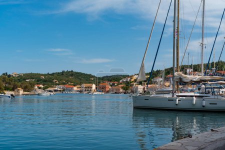 Photo for Gaios harbour at Paxos Greek Island, 31 May 2024: view of village promenade frontline of the berth with boats, shops, tavernas - Royalty Free Image