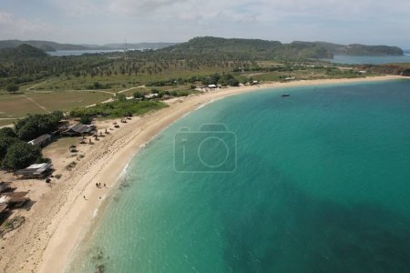 Luftaufnahme des Tanjung Aan Strandes auf der Insel Lombok, West Nusa Tenggara Indonesien. Weißer Sandstrand mit klarem Meerwasser, grün-türkisfarbenem Strand und klarem blauen Himmel. 