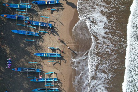 fishing boats anchored on the shore. Indonesia is the largest maritime country in the world that produces a lot of fish catches from the ocean. kapal nelayan pantai Pangandaran. aerial view of shore. white wavy beach. 