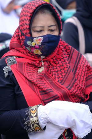 Téléchargez les photos : Yogya, Indonésie. Le 12 mai 2021. Prière de l'Aïd al-Fitr tenue pendant la pandémie de COVID-19, adorateur tenu de porter un masque et de garder leurs distances avec les autres adorateurs. - en image libre de droit