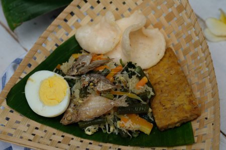Foto de Gudeg krecek es un alimento tradicional de Yogyakarta hecho de jaca joven, huevo, pollo, leche de coco, azúcar morena y especias. servido en contenedores de bambú tejido y hoja de plátano. Alimentos indonesios. - Imagen libre de derechos