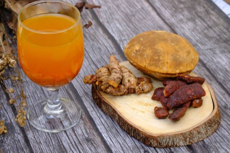Foto de Jamu Kunir Asem es una bebida herbal javanesa tradicional hecha de cúrcuma, tamarindo, azúcar morena y agua. Se cree que esta bebida amarilla tiene beneficios para la salud y puede estimular el sistema inmunitario.. - Imagen libre de derechos