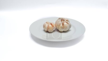 Foto de Raw whole garlic on white plate isolated on white background - Imagen libre de derechos