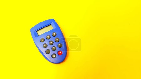 Téléchargez les photos : Blue internet banking token used to generate passwords for online transactions isolated on yellow background. - en image libre de droit