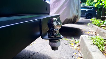 Close up view of tow bar and tow ball on a car. Outdoors.