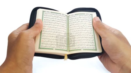 Photo for Man reading the holy quran. Hand holding a Holy Quran on white background. - Royalty Free Image