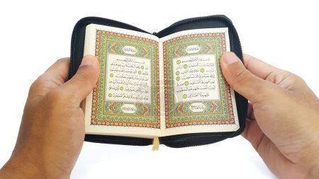 Téléchargez les photos : Man reading the holy quran. Hand holding a Holy Quran on white background. - en image libre de droit