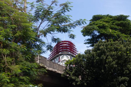 Foto de Yakarta, Indonesia - 08 de febrero de 2024: Vista de una esquina del edificio entre una arboleda de árboles. Edificio del parque de oficinas Menteng en el centro de Yakarta. Edificio HDI Hive Menteng. - Imagen libre de derechos