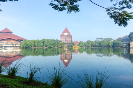 Foto de Depok, Indonesia - 10 de abril de 2024: Vista del lago Kenanga con el fondo del edificio rectorado de la Universidad de Indonesia en Depok, Indonesia - Imagen libre de derechos