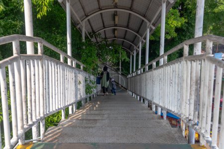 Vista de personas cruzando el puente peatonal en Yakarta