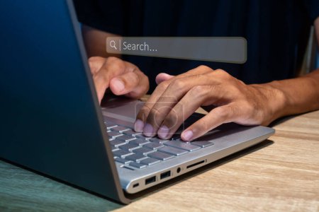Foto de Un hombre que usa un portátil para buscar información. Concepto de optimización de motores de búsqueda. - Imagen libre de derechos