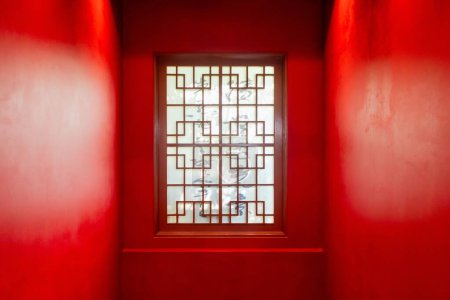 Wooden window in red wall with traditional Chinese style. Interior view.