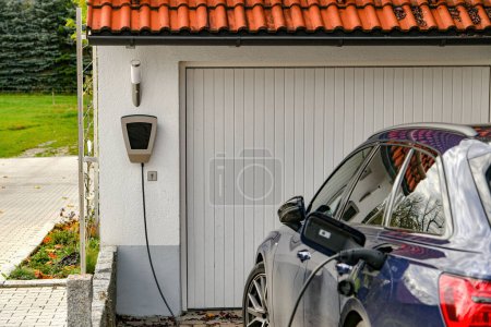 Téléchargez les photos : Une voiture électrique est chargée depuis une station-service dans une maison privée. - en image libre de droit