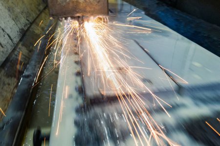 Photo for Grinding the plate on a surface grinding machine. Sparks and water cooling on a magnetic table - Royalty Free Image