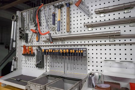 Photo for Square slot screwdrivers, keys and various tools hang on a rack in a locksmith workshop. - Royalty Free Image